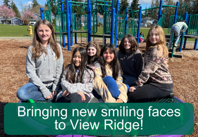  Kids smiling at the camera on the playground.